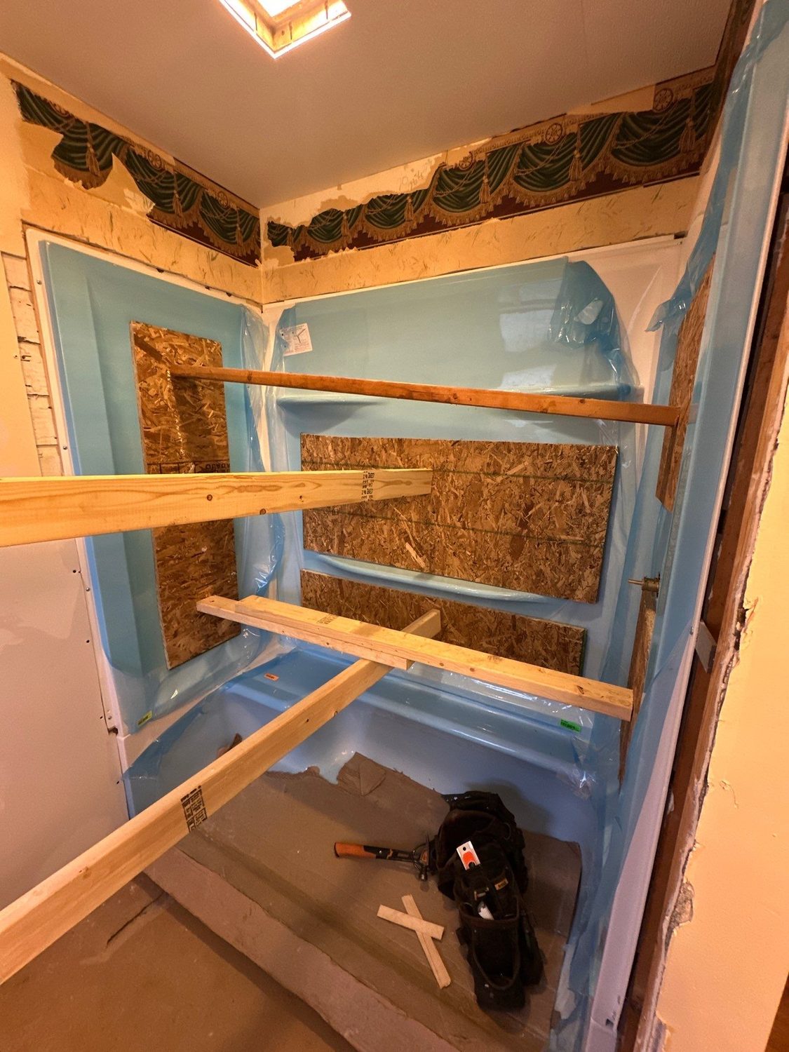 Shower alcove rebuilt with waterproof backer board and solid wood blocking set into the walls for grab bars